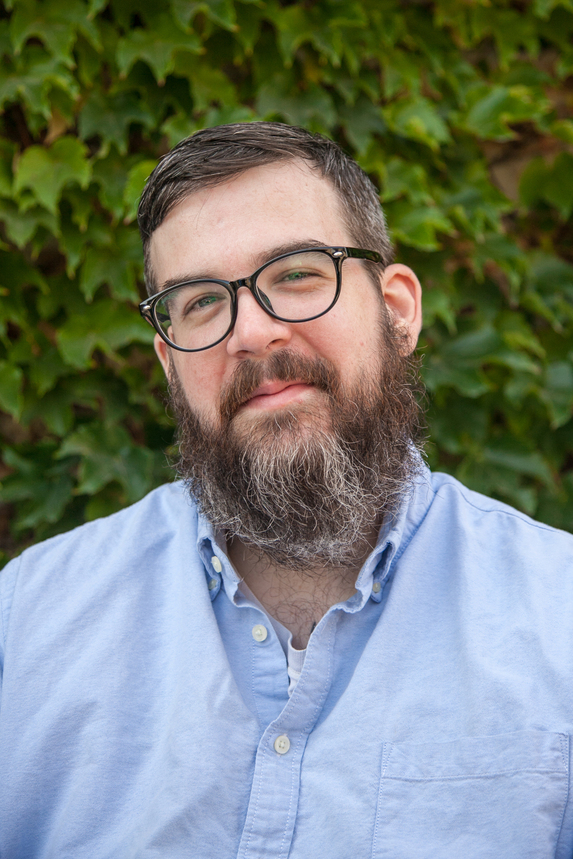 A smiling bearded fellow, now in a light blue shirt